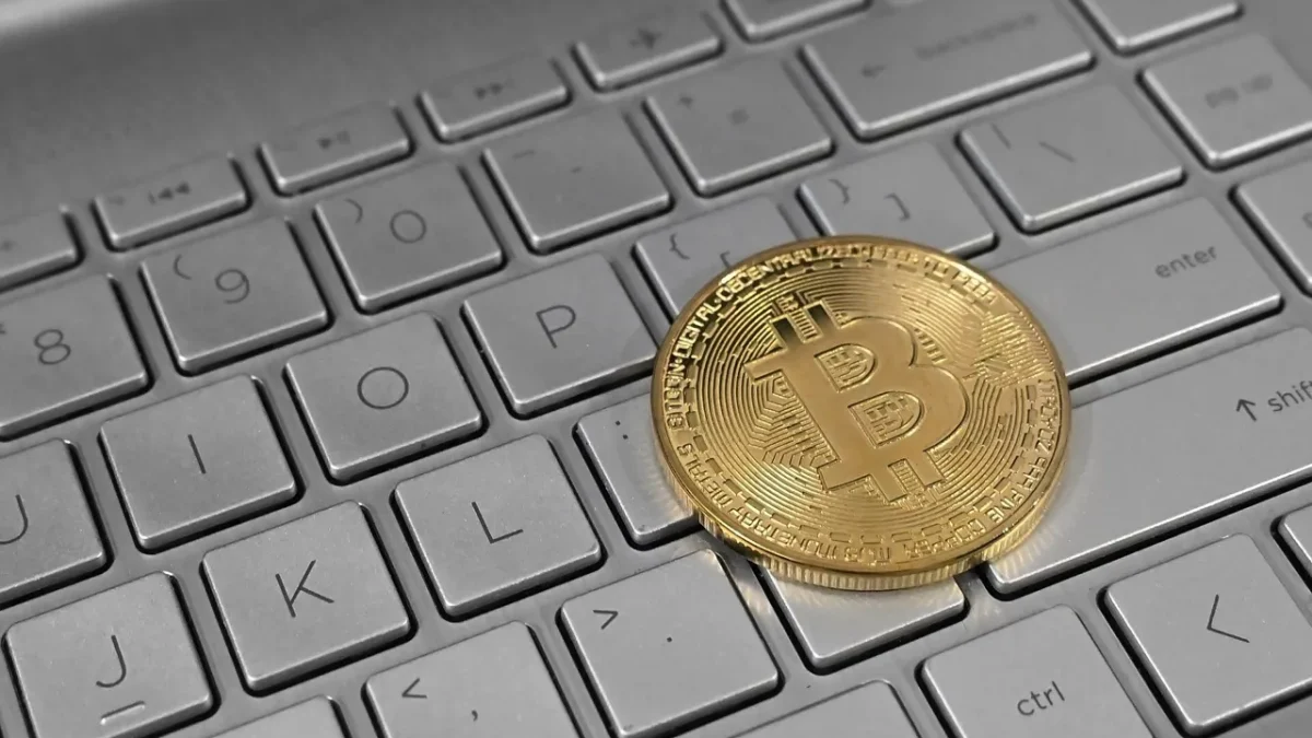Pièce de bitcoin posée sur un clavier d’ordinateur portable